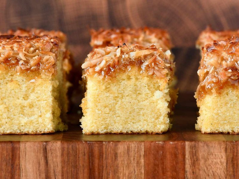 3 slices of cake up close side view vanilla cake with broiled coconut icing on board