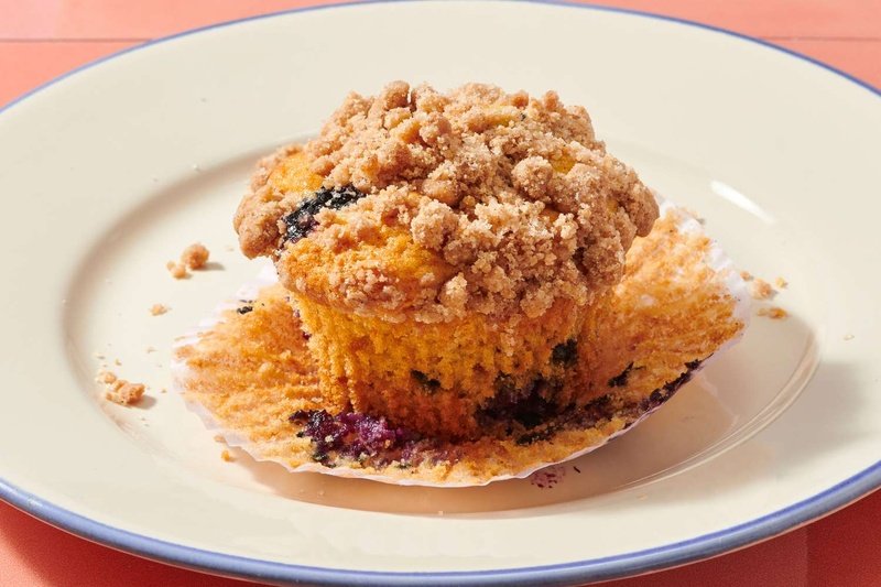 A blueberry muffin with a crumb topping on a plate