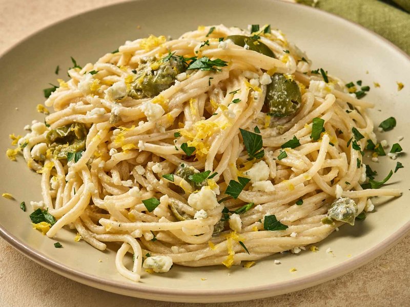 Spaghetti with a creamy sauce, garnished with cheese and herbs