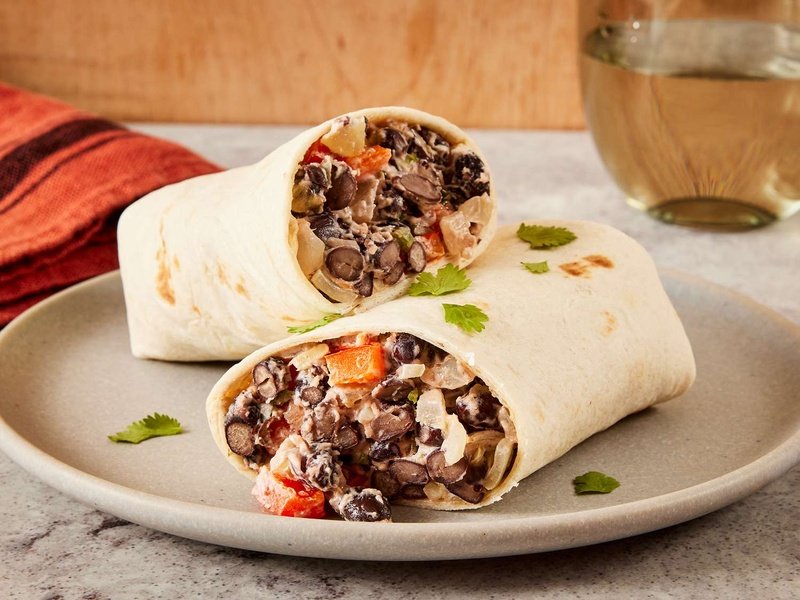 close up on two black bean burritos resting on top another
