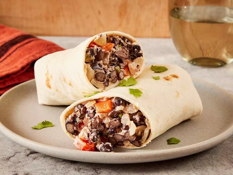 Close up on two black bean burritos resting on top another