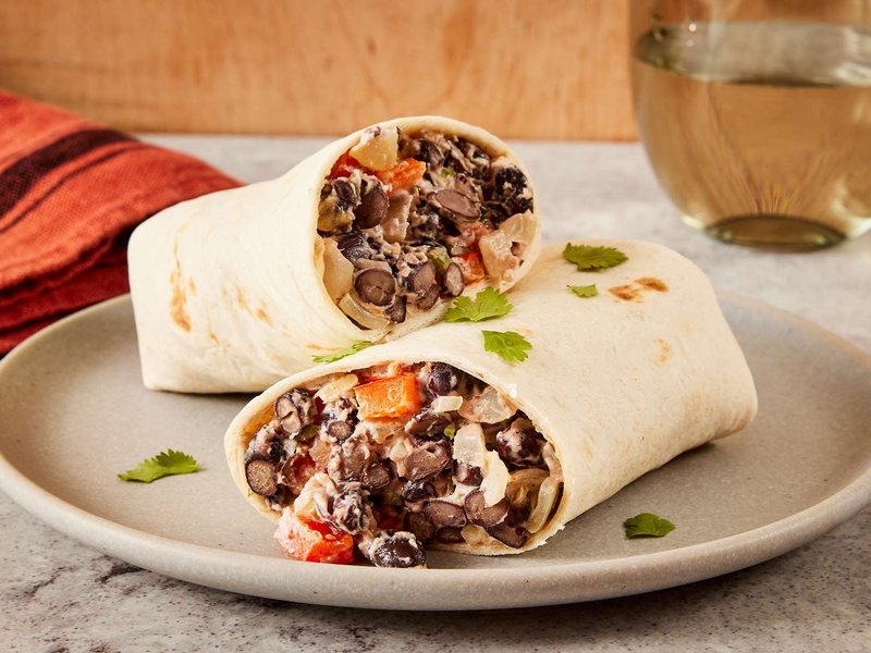 Close-up on two black bean burritos resting on top of another
