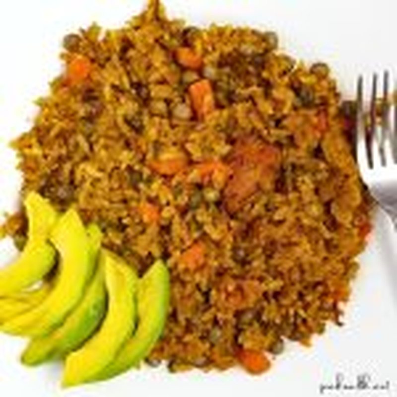 trinidad chicken pelau on white plate with avocado slices